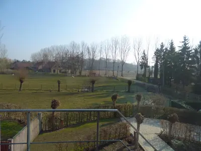 a view of a park with trees and a fence at B&B Hier en Nu in Heusden