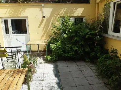 a garden outside a house with a bench and a bush at Casa di Cynthia in Antwerp