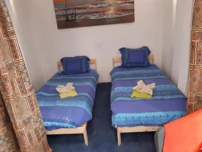 two twin beds in a room with curtains at Casa di Cynthia in Antwerp