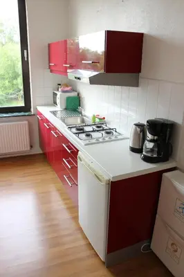 a kitchen with red cabinets and a stove top oven at Brussels BnB in Brussels