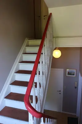 a staircase with a red hand rail in a house at Brussels BnB in Brussels