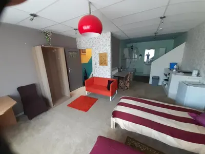 a living room with a bed and a red couch at casa di Claudia in Antwerp