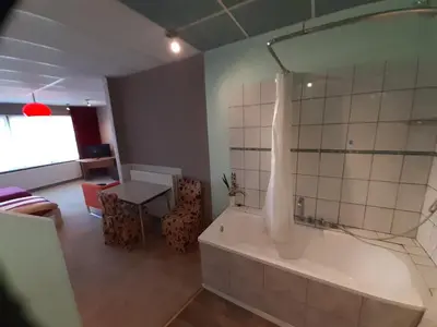 a bathroom with a tub and a table and a room at casa di Claudia in Antwerp