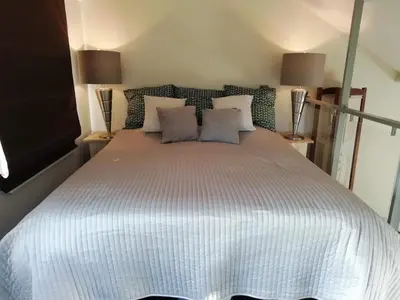 a bedroom with a large white bed with two lamps at The Mill 2380 in Ravels