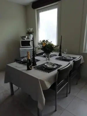 a table with a white table cloth and a bottle of wine at The Mill 2380 in Ravels
