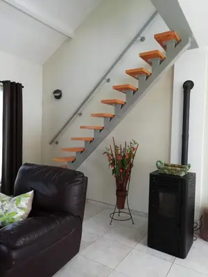 a living room with a couch and a staircase at The Mill 2380 in Ravels