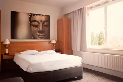 a bedroom with a bed with a head on the wall at Domein Martinus in Halle