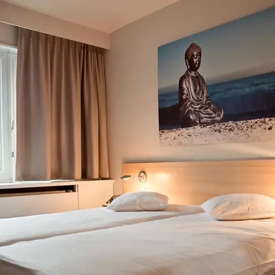 a bedroom with a bed with a statue on the wall at Domein Martinus in Halle