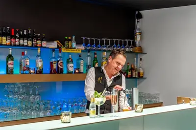 a bartender making a drink at a bar at Domein Martinus in Halle