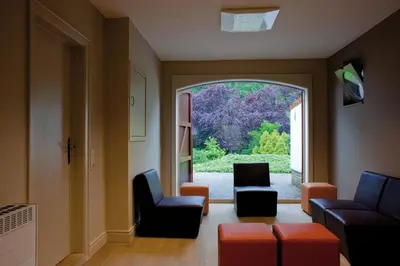a living room with a large window and chairs at Domein Martinus in Halle