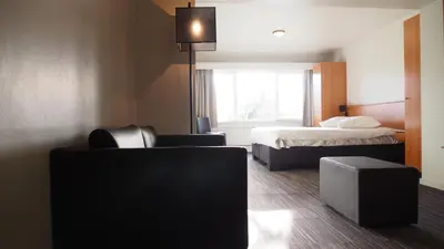a hotel room with a bed and a bed and a couch at Domein Martinus in Halle