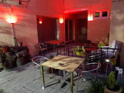 a table and chairs in a room with red lighting at casa di Gino in Antwerp