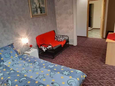 a bedroom with a bed and a red chair at casa di Gino in Antwerp