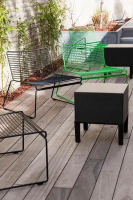 three chairs and a bench on a wooden deck at B&B Snooz Inn in Ghent