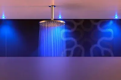 a bathroom with a shower with a blue curtain at B&B Snooz Inn in Ghent