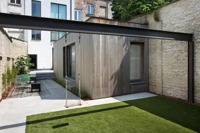 a modern house with a wooden door and a yard at B&B Snooz Inn in Ghent