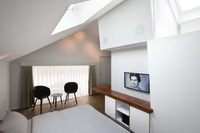 a living room with a bed and two chairs at B&B Snooz Inn in Ghent