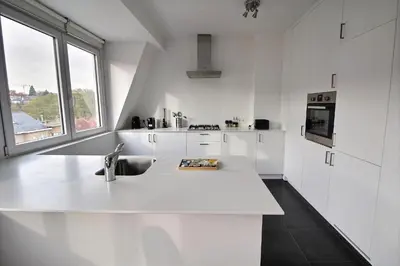 a white kitchen with a sink and a window at Rent a flat - Montgomery in Brussels