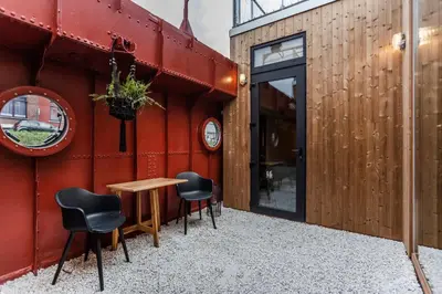 a patio with a table and chairs next to a building at Juno Boat in Ghent
