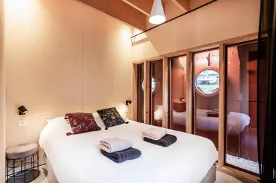 a bedroom with a white bed with towels on it at Juno Boat in Ghent