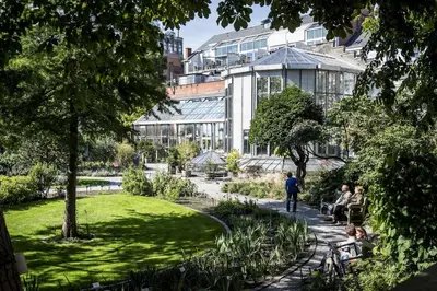 people sitting in a park in front of a building at Theaterstudio 2 Antwerp in Antwerp