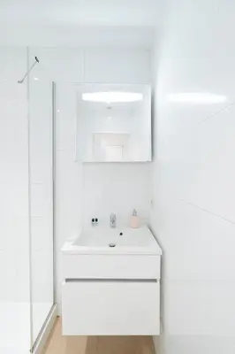 a white bathroom with a sink and a mirror at Theaterstudio 2 Antwerp in Antwerp