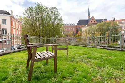 a bench sitting in the grass in a city at EU Parliament Terrace Residence in Brussels