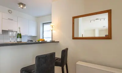 a kitchen with a mirror and a chair in a room at EU Parliament Terrace Residence in Brussels
