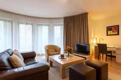 a living room with a couch and a television at EU Parliament Terrace Residence in Brussels