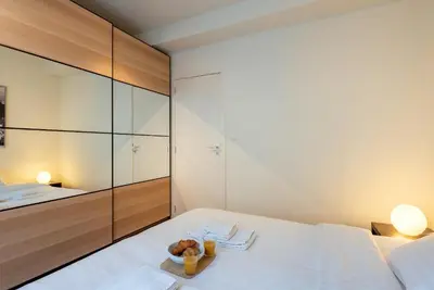 a bedroom with a white bed with a bowl of food on it at EU Parliament Terrace Residence in Brussels