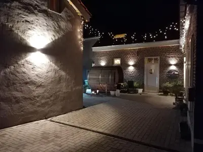a courtyard at night with a wine barrel and lights at B&B Leybeeckhof in Holsbeek
