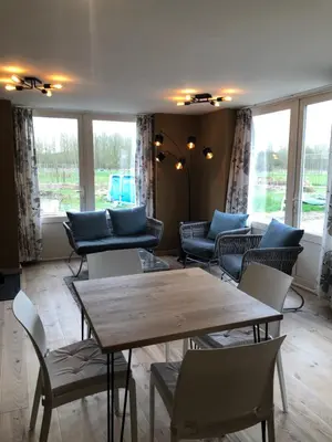 a room with a table and chairs and windows at B&B Leybeeckhof in Holsbeek