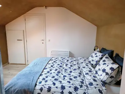 a bedroom with a bed with blue and white sheets at B&B Leybeeckhof in Holsbeek