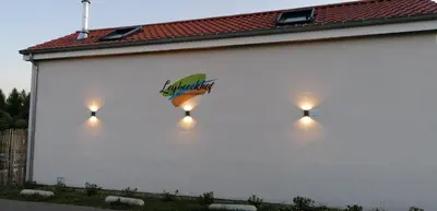 a white building with lights on the side of it at B&B Leybeeckhof in Holsbeek