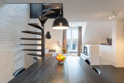 a dining room table with a bowl of fruit on it at Flagey Penthouse Duplex in Brussels