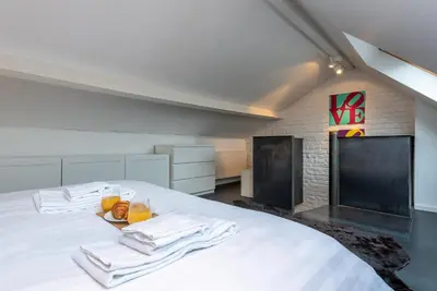 a bedroom with a white bed with towels on it at Flagey Penthouse Duplex in Brussels