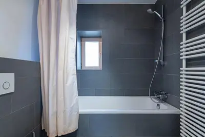 a bathroom with a bath tub and a shower curtain at Flagey Penthouse Duplex in Brussels