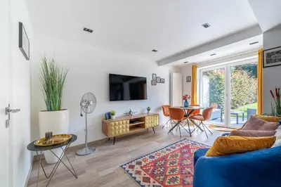 a living room with a blue couch and a table at COZY APARTMENT IN BRUSSELS in Brussels