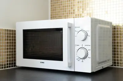 a white microwave oven sitting on top of a counter at COZY APARTMENT IN BRUSSELS in Brussels