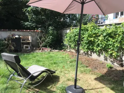 a chair and an umbrella in a yard at Best nest in Brussels