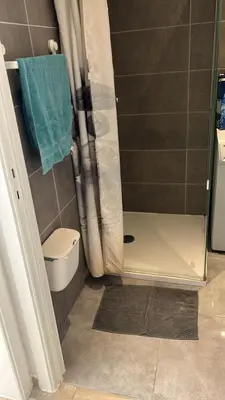 a bathroom with a shower with a toilet and a blue towel at Best nest in Brussels