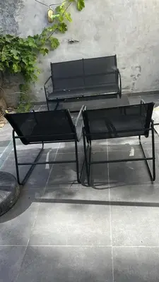 two black benches sitting next to a wall at Best nest in Brussels