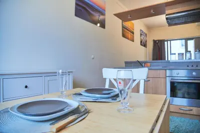 a kitchen with a table with plates and glasses on it at Studio au plein centre de la ville in Brussels