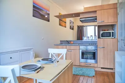 a kitchen with a table and chairs in a room at Studio au plein centre de la ville in Brussels