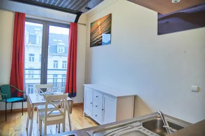 a kitchen and dining room with a table and a window at Studio au plein centre de la ville in Brussels