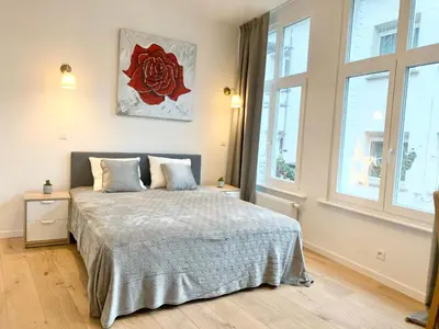 a bedroom with a bed and two windows at Luxury Suites Riverside Residence by Rikas Hotels in Antwerp
