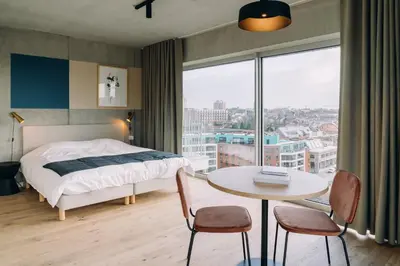 a bedroom with a bed and a table and a window at De Hoorn in Leuven