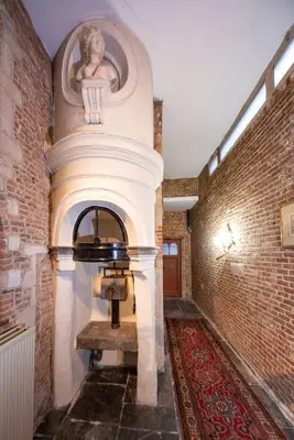 a room with a brick wall and a niche with a statue at HOFMARKGRAAF - Unique apartment in historic Antwerp mansion in Antwerp