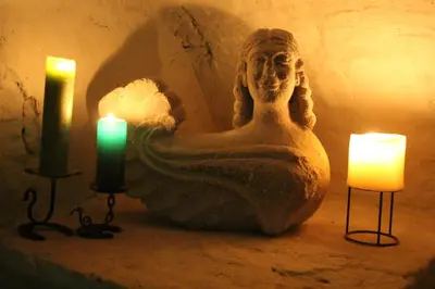 a statue of a woman sitting next to two candles at HOFMARKGRAAF - Unique apartment in historic Antwerp mansion in Antwerp