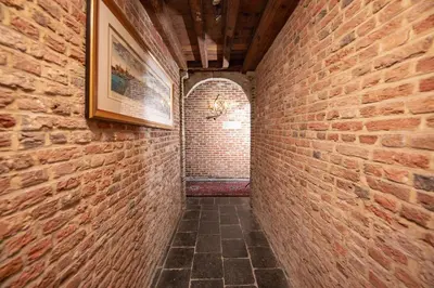 a brick hallway with a picture on a brick wall at HOFMARKGRAAF - Unique apartment in historic Antwerp mansion in Antwerp